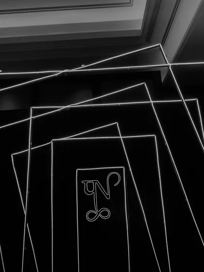 A custom neon light installation featuring the couple's monogram, designed in a geometric, Art Deco style. These personalized details make the event unique.