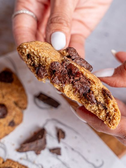 The classic "cookie break" shot. This image, showing a gooey, melted chocolate chip cookie being broken in half, is designed to trigger an immediate craving. It’s a powerful shot for any bakery or cafe.