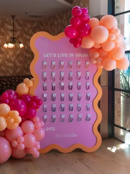 An interactive brand activation setup for a PR event. This custom board invites guests to 'Live in Color' and take a branded keychain.