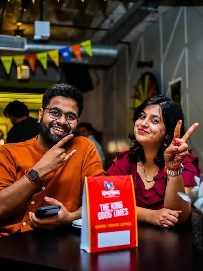 A couple enjoying their time, flashing peace signs and smiles. It's all about good times and good company.