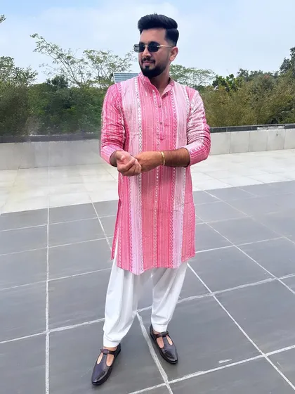 This is my signature 'Desi Kalakaar' style. A vibrant, embellished pink kurta paired with a classic white salwar is the perfect look for a daytime wedding event like a Haldi or Mehendi ceremony.