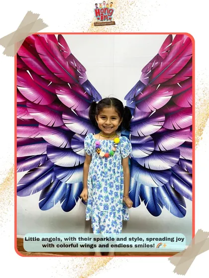 A happy student poses with our colorful angel wings backdrop. Her bright smile captures the joyful and imaginative spirit we encourage at Hangin.