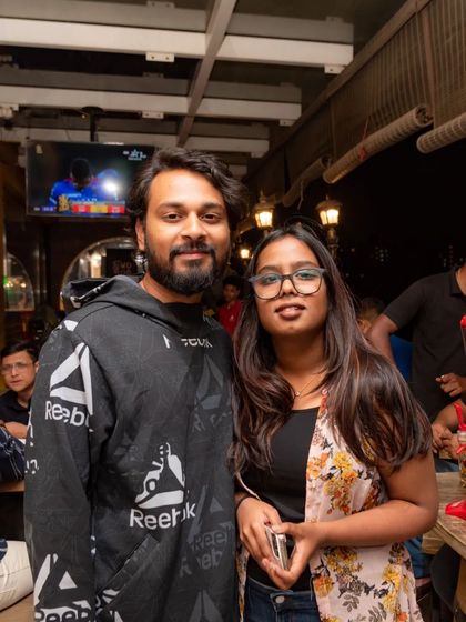 A couple enjoying the pub atmosphere with a beer tower nearby. The screen in the background shows that even on a regular night, there's always a game to watch.