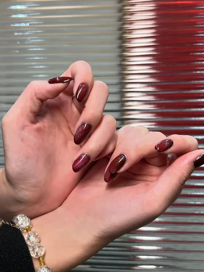 A closer look at the texture and shine of this deep red manicure. The subtle shimmer in the polish gives it a beautiful, multi-dimensional look.
