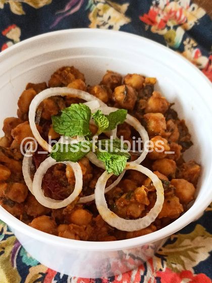 Enjoy a bowl of my tasty Chana Batata, garnished with fresh mint leaves.