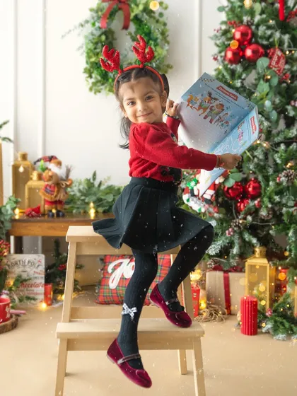 The excitement of receiving a special gift. This action shot captures the pure energy and happiness of a child during the most wonderful time of the year.
