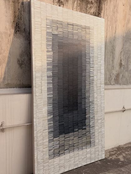 The large textured piece standing in the sun. The light brings out the subtle variations in the grey tones and the texture of the individual brushstrokes.