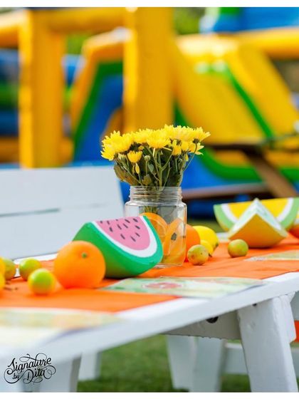 A close-up of the table decor for the 'Two-tti Fruity' party. I used fresh flowers and hand-painted fruit props to create a fresh and vibrant tablescape.