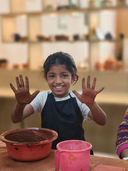 The pure joy of a child with clay-covered hands. Our workshops are designed to be fun and accessible for all ages, making art a happy and memorable experience.
