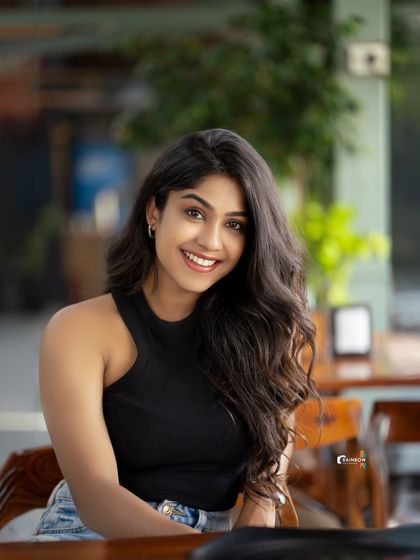 A happy and relaxed portrait of a model in a casual outfit, taken in a cafe.