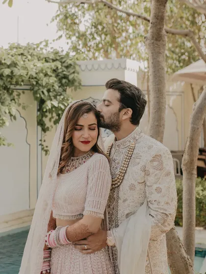 A tender moment between the bride and groom. The soft, natural light and the elegant backdrop of the palace create a romantic and timeless photograph.