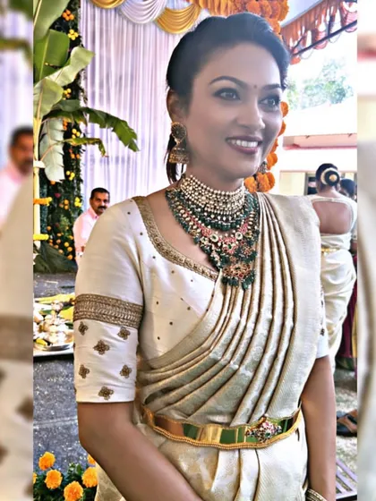 A client looking elegant in an off-white Kanchipuram saree. Her custom blouse features simple butti embroidery and a detailed border on the sleeves.