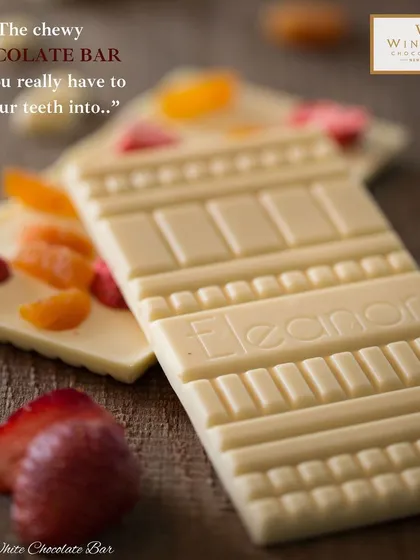 This is our Eleanor White Chocolate Bar, a perfect example of our premium couverture chocolate capabilities. The bar features real fruit pieces and a custom mould, showcasing the artisanal quality and attention to detail we bring to every product.