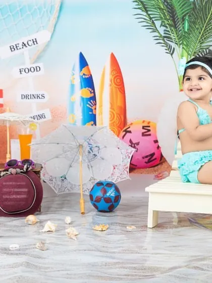 This little girl is enjoying a day at the beach, clapping her hands with joy.