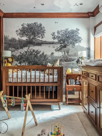 A closer look at the crib and changing area in this safari-themed nursery. The black and white wallpaper creates a sophisticated yet gentle backdrop, proving that nurseries can be both classy and cozy.