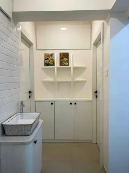 This entryway makeover demonstrates my focus on creating functional beauty. I designed a custom storage unit with open shelving between two doors, providing a practical space for essentials while maintaining a clean, organized look.