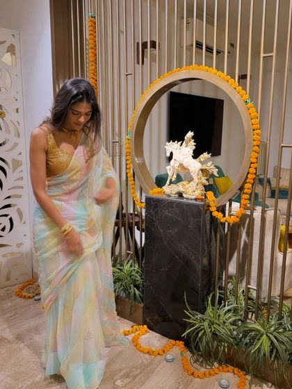 Adjusting my saree at home. This candid shot highlights the delicate fabric and the way the colors blend together, perfect for a festive but not overly heavy look.
