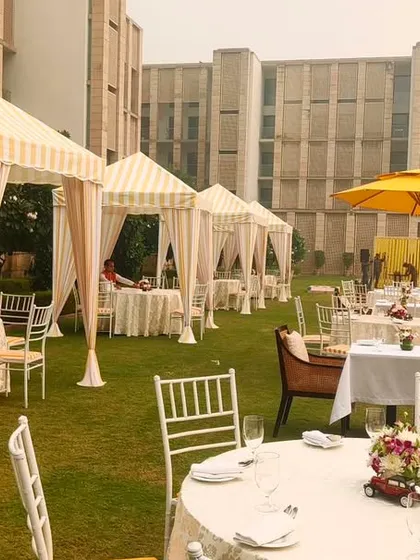 A wider shot of the elegant brunch event at The Lodhi, showing multiple cabanas and dining tables set up across the lawn for a large yet intimate gathering.