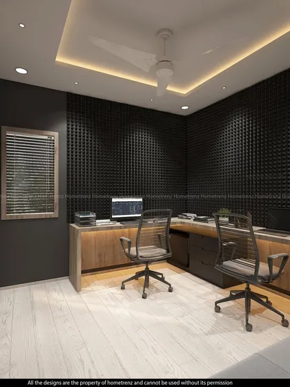A dual-person workspace with ergonomic chairs. The acoustic paneling on the wall is perfect for a home office where calls and meetings are frequent.