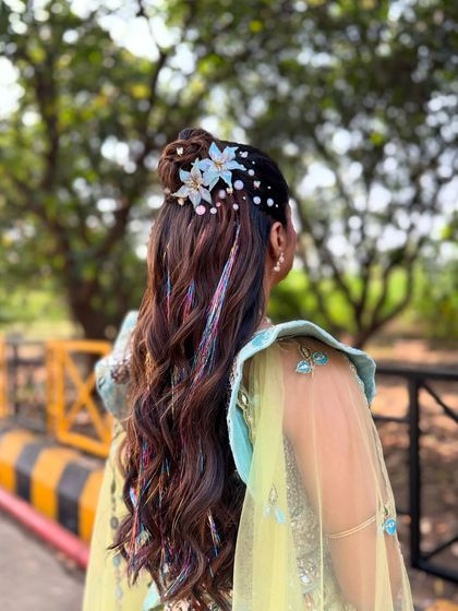 A side view of the carnival hairstyle, showing how the floral clips and pearls are scattered to create a whimsical, garden like effect.