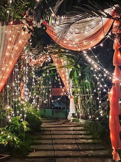 Step into another world through this enchanting entrance, draped in soft fabrics and illuminated by hundreds of warm fairy lights.