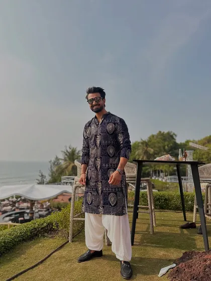A full-length shot showcasing my outfit against the beautiful Goa backdrop. I always dress to impress and match the event's theme.
