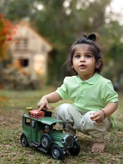 This little explorer is playing with a vintage toy car in a garden setting. Outdoor shoots are great for letting kids play and be themselves.