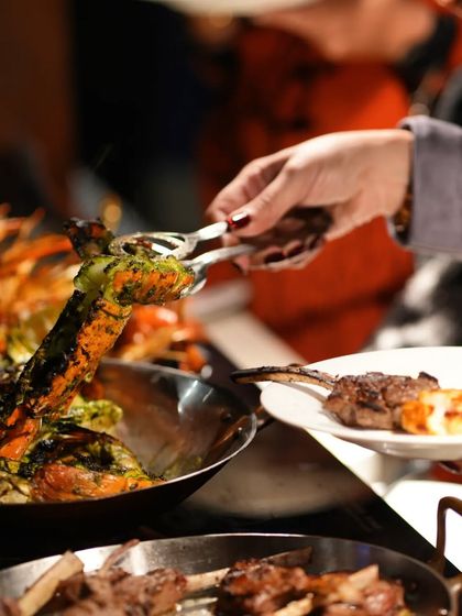 A guest helping themselves to grilled lobster from a buffet. Our event menus can be customized to include luxurious items like this.