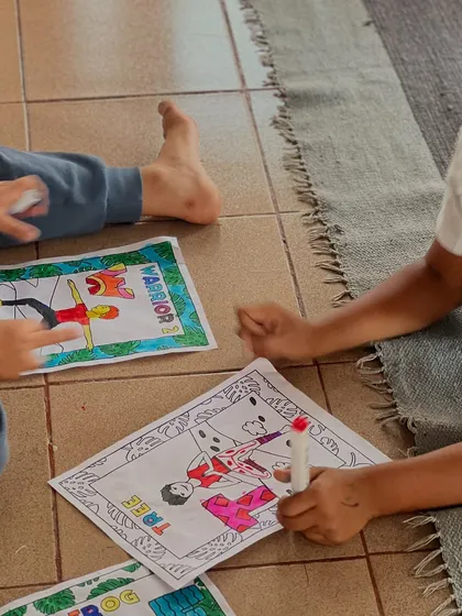 Two boys discuss their coloring of Warrior and Tree poses. They learn from each other and share their creative ideas.