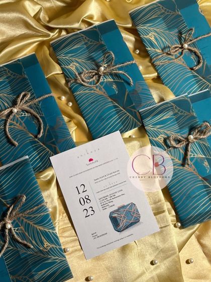 Aesthetic and budget-friendly invitations perfect for any event. These cards feature a beautiful teal and gold peacock feather design, tied with jute string and a pearl, offering a touch of luxury without a high price tag.