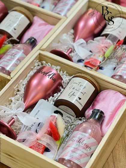 An overhead view of a fully packed bridesmaid proposal box. You can see all the curated items nestled together, including a personalized candle, wine glass, satin pillowcase, and other pampering treats.