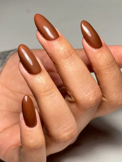 A sun-kissed shade of brown. A simple, elegant set of long almond acrylic extensions in a beautiful solid brown color.
