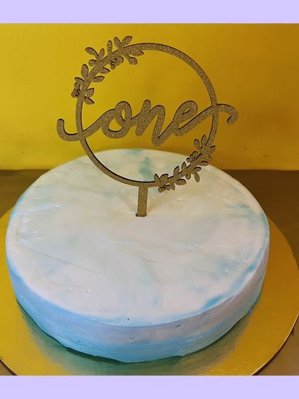 Celebrating a first birthday is a huge milestone. This simple and elegant cake, with a "one" topper, was made with a decadent dark chocolate and cream flavor, perfect for a little prince's special day.