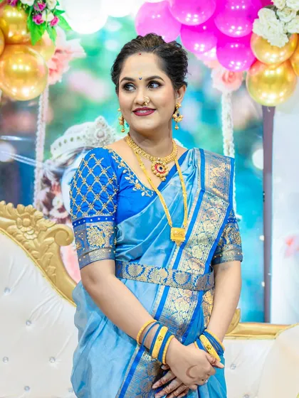 This new mother of twins is glowing for their naming ceremony. The makeup features a bold lip that contrasts beautifully with her blue silk saree.