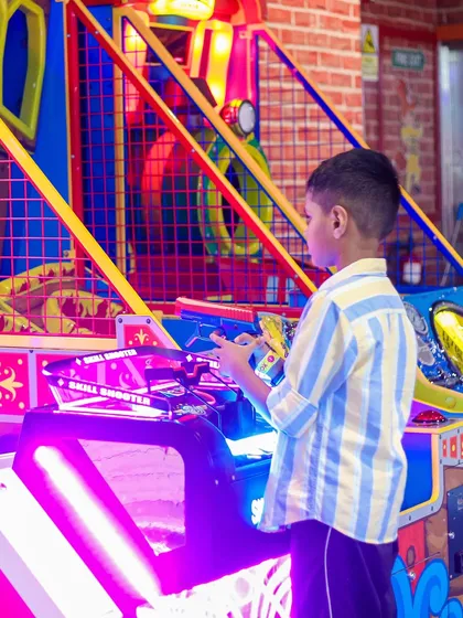 A boy takes aim at the "Skill Shooter" arcade game. It's a fun challenge for those with a competitive spirit.