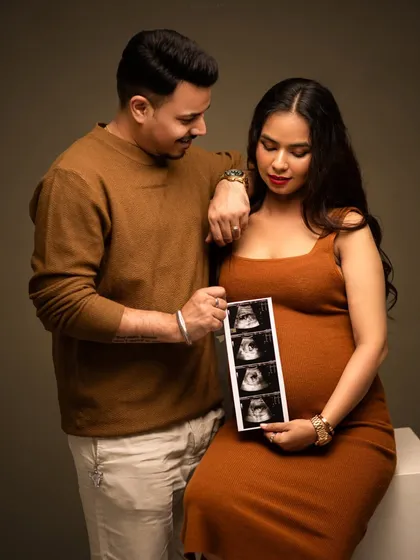 The first picture. This couple proudly displays their baby's sonogram, a simple and powerful way to include their little one in the maternity photoshoot.