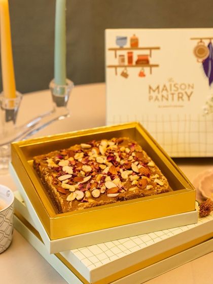 A close-up of my Masala Gur box, set in a festive ambiance with candles. This highlights the product as a perfect addition to your festive decor and celebrations.