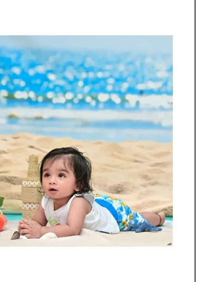 Lying on his tummy in the sand, this little boy looks up with a curious expression. This pose is great for capturing sitter-age babies and their growing strength.