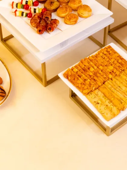 An overhead shot of the pastries and canapés served at the L'Opéra event. The clean, geometric presentation on white platters reflects a modern and sophisticated style.