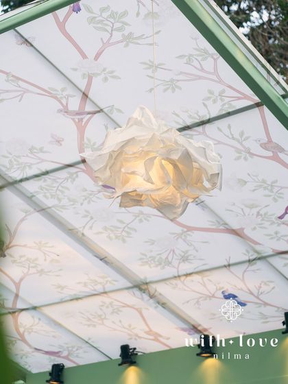 A custom paper flower light fixture from 'The Conservatory' baby shower, adding a touch of handmade artistry.