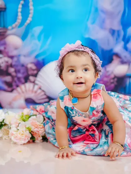 Crawling through her ocean wonderland. The floral dress provides a lovely contrast against the blue background.
