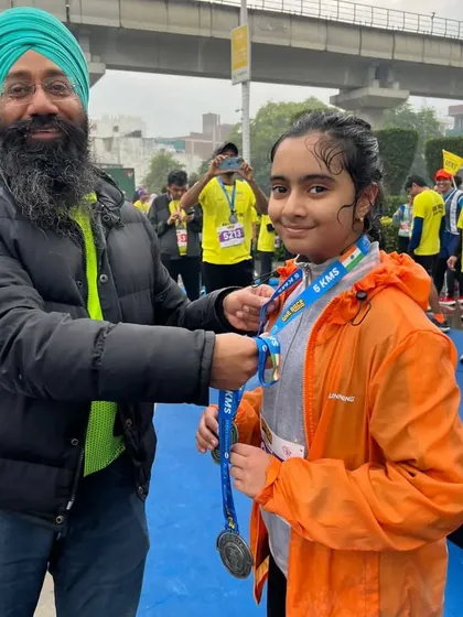 A young runner receiving her medal from a race official. A moment she will never forget.