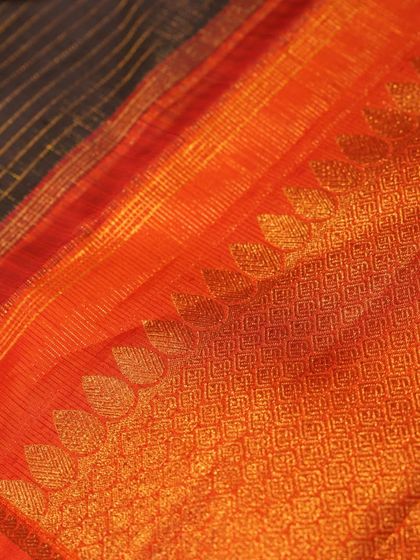 The pallu of the black and orange Kanjivaram, featuring leaf motifs in gold zari.