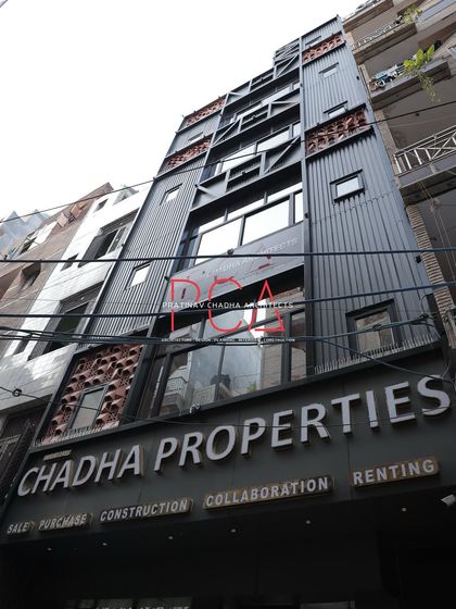 A full daytime view of the Chadha Properties office facade. This shot provides a comprehensive look at the vertical design, which incorporates modern industrial materials with traditional Indian jaalis.