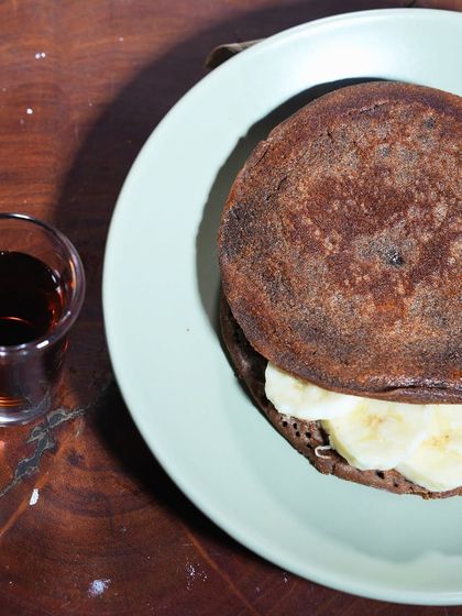 A nourishing and hearty option, my Ragi Pancakes are made from wholesome finger millet flour. They are served with fresh banana slices and a side of syrup.