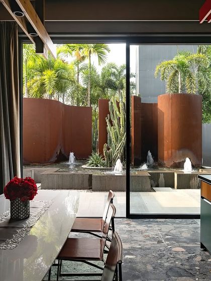 A view from inside KEUS looking out at the Corten steel walls and fountains. The landscape is designed to be a dynamic backdrop that changes with the light throughout the day.