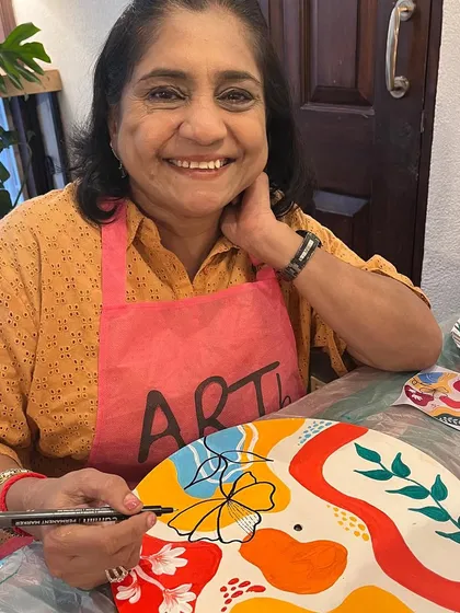 A smiling lady adding details to her boho clock during a creative kitty party. I provide all the materials and guidance to make it a fun experience for everyone.