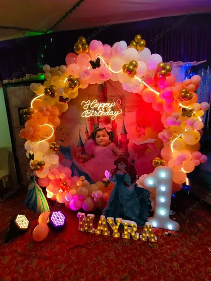 A princess-themed first birthday with a warm-toned balloon circle and butterfly accents.