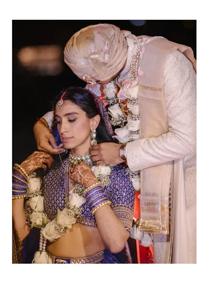 A tender moment as the groom helps the bride with her necklace. These quiet acts of love and care are the threads that weave the beautiful tapestry of a wedding day.