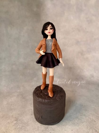A full view of one of my favourite fondant figurines, showing her stylish outfit and confident pose on a cobblestone base.